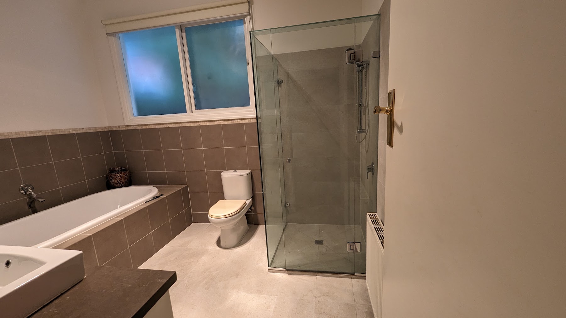 Melbourne Home Makeover bathroom with bathtub, tiled walls and glass shower enclosure